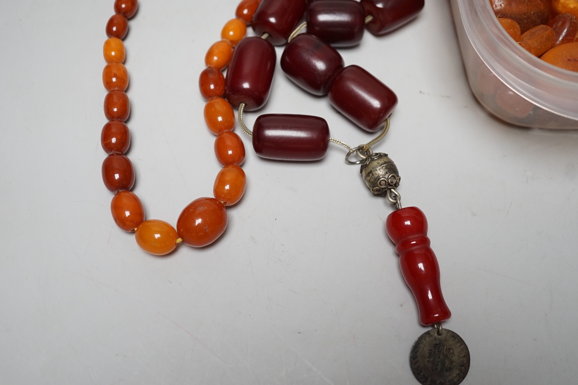 A single strand graduated amber bead necklace, 54cm gross weight 30 grams, together with loose amber beads, gross 153 grams and a simulated cherry amber necklace.